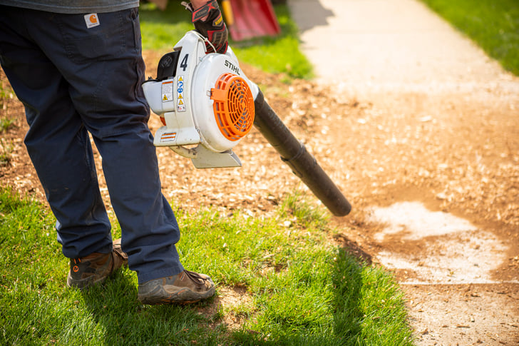 arborist cleaning up after grinding a tree stump