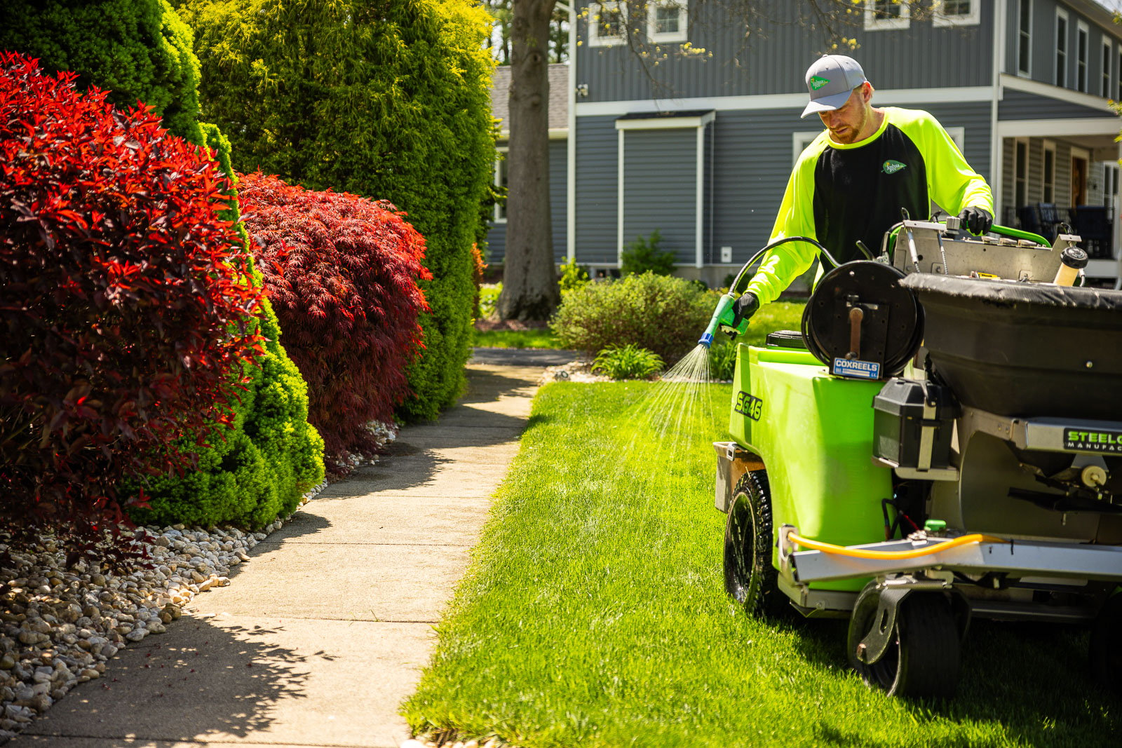 lawn care technician spraying a lawn edge for weed control 2