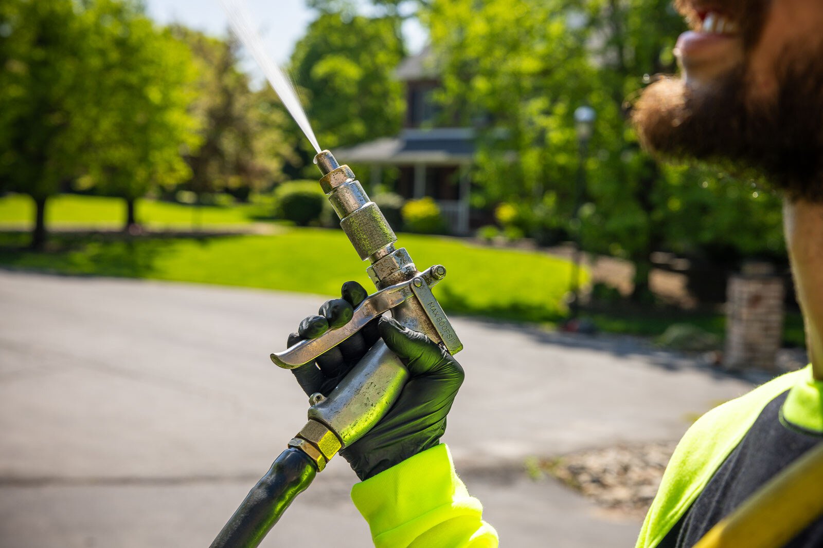 plant health care technician spraying a tree canopy with foliar spray